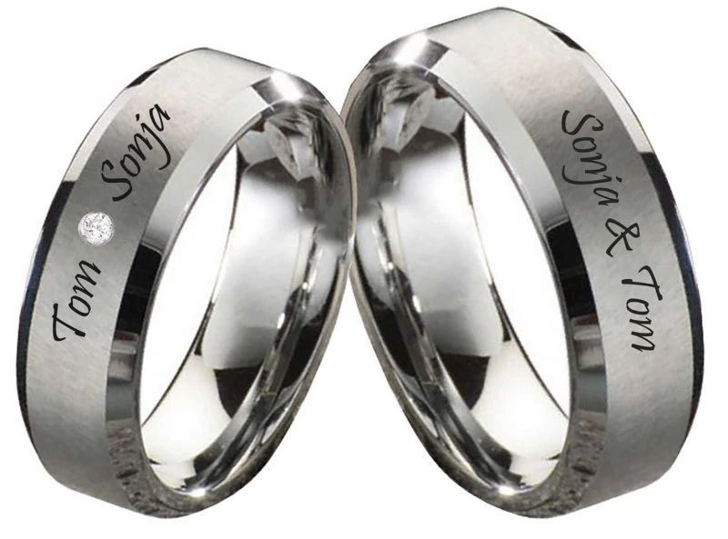 Moderne Wolframringe aus robustem Wolframcarbid in 8 mm Breite: ein Herren‑ und ein Damenring mit mattierter und polierter Oberfläche, individuelle Lasergravur auf der Außenseite und ein eingefasster Zirkonia‑Stein im Damenring.